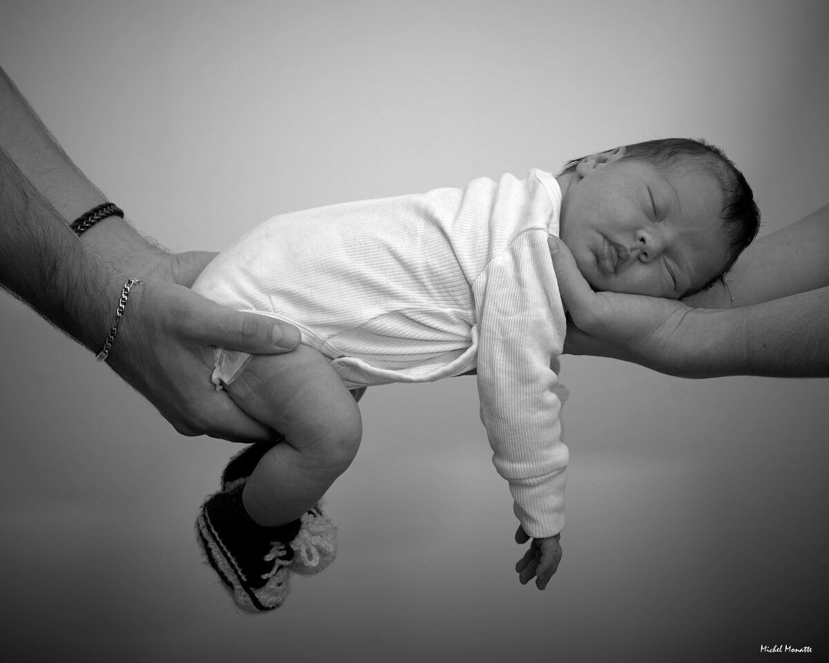 Photo nouveau-né bébé tenu par les parents Michel Monatte photographe Toulouse
